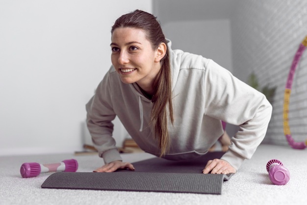 mulher fazendo flexão de braços em casa