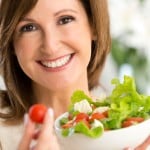 Mulher adulta comendo salada