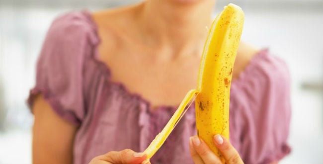 Mulher descascando banana