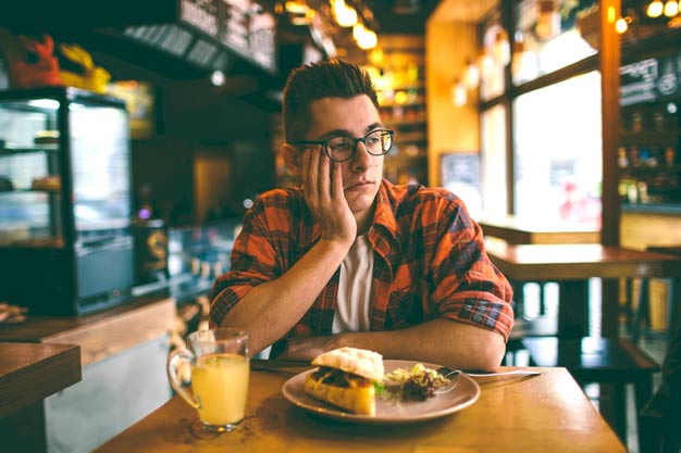 homem sem apetite no restaurante