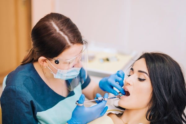 dentista aplicando anestesia local
