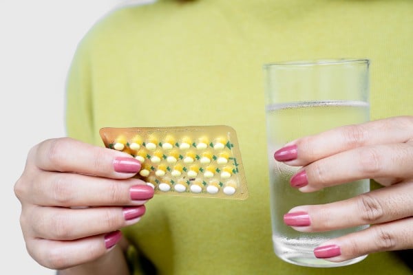 mulher tomando pílula