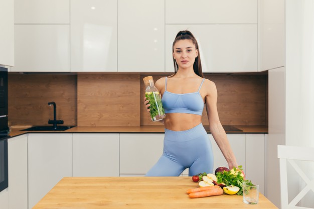 mulher magra segurando água com limão