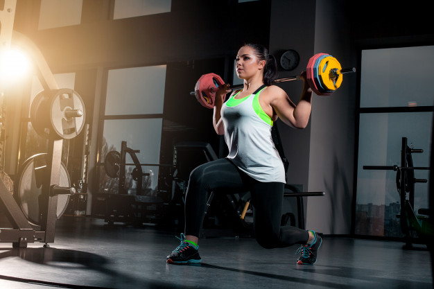 body pump mulher fazendo agachamento com barra