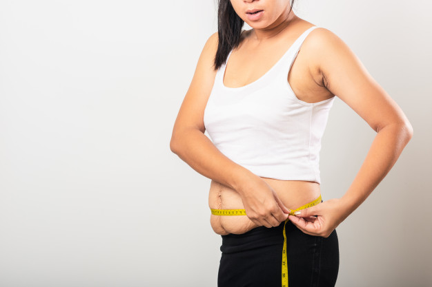 mulher medindo com fita métrica a barriga