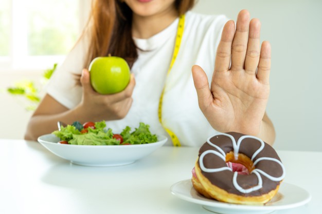 mulher recusando um alimento processado