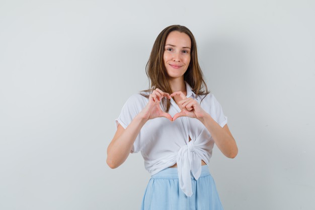 mulher feliz fazendo o símbolo do coração