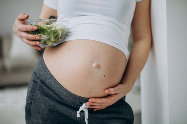 Grávida comendo salada