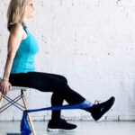 Extensão de perna sentado no banco usando elástico - Como fazer e erros comuns