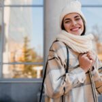 Jovem sorridente andando na rua no inverno.