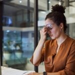 Mulher enfrentando burnout digital em seu trabalho, em um escritório