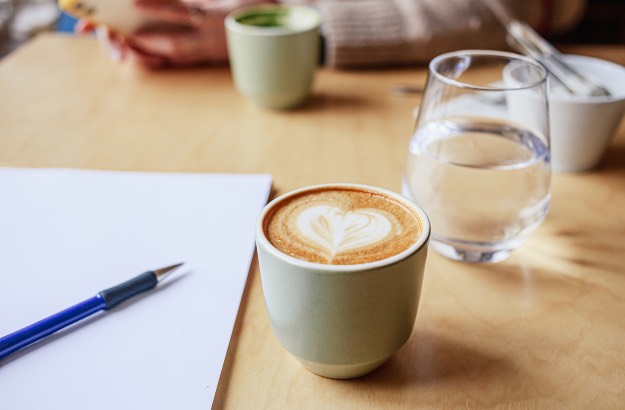 Imagem de reunião de terabalho bebendo café acompanhado de água. 