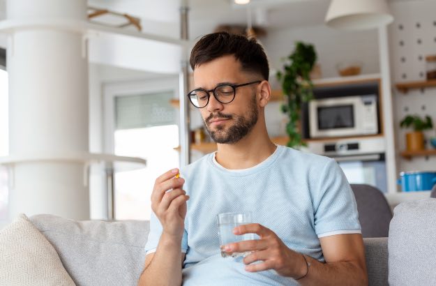 Jovem tomando medicamento para tratamento de TDAH 