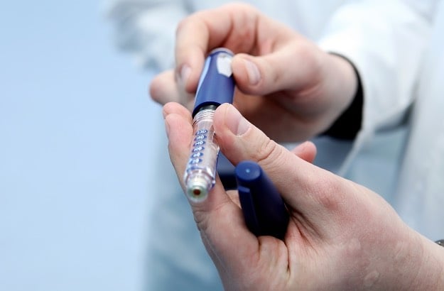 Cartucho de insulina e ampola nas mãos de um médico 