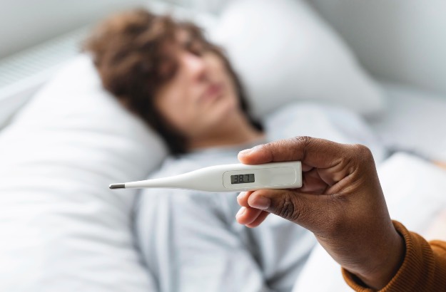 Jovem com Febre e mulher observando temperatura corporal 