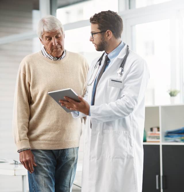 Homem conversando com o médico e vendo exame em um tablet digital 