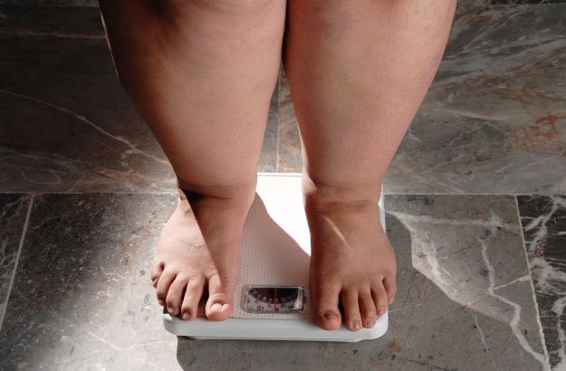 Pés de mulher com excesso de peso se pesando