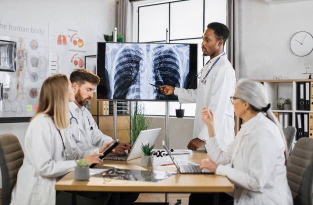 Diversos médicos verificando a radiografia dos pulmões 