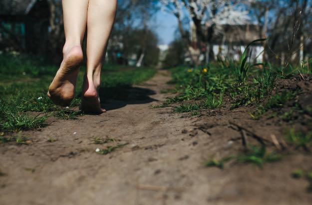 Menina descalça em chão de terra