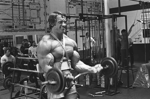 Arnold Schwarzenegger malhando pesado na academia 