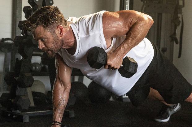 Chris Hemsworth fazendo flexão com halteres