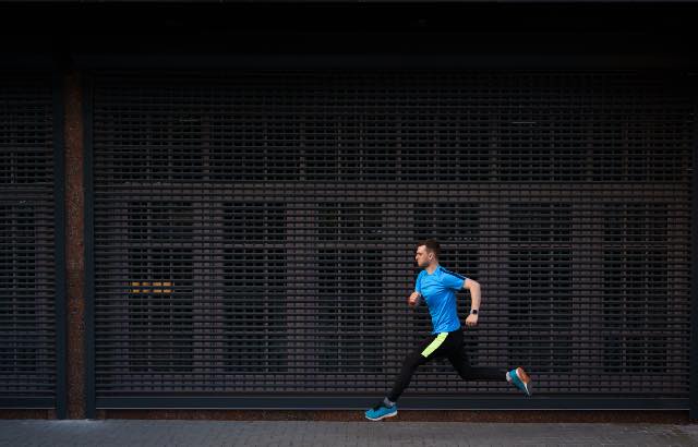 Homem atlético correndo ao ar livre para competir em uma maratona 