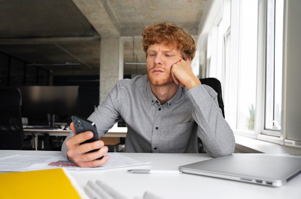 Homem procrastinando no escritório devido ao TDAH