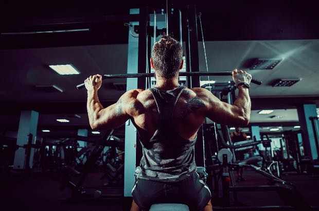 Homem treinando na academia em um treino puxada alta