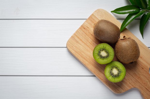 Kiwi em uma tábua em fundo branco 