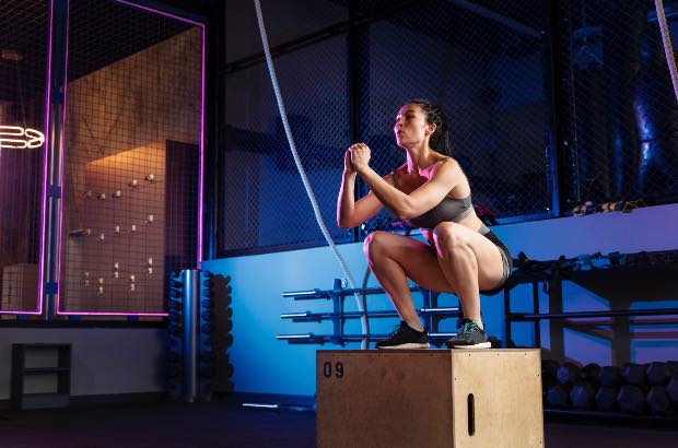 Menina treinando crossfit na academia para definição corporal 