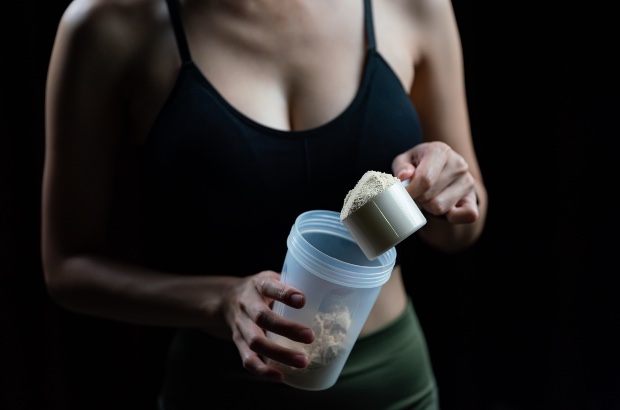 Mulher preparando creatina em uma shakeira para ir treinar 