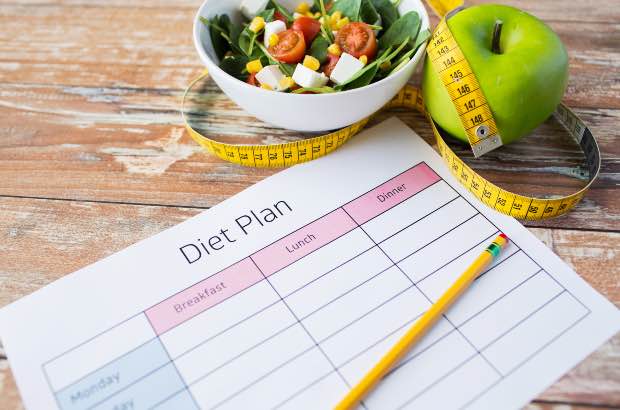 Plano de dieta com fruta e legume em fundo amadeirado 