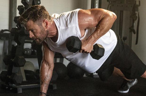 Chris Hemsworth treinando flexão com pesos 