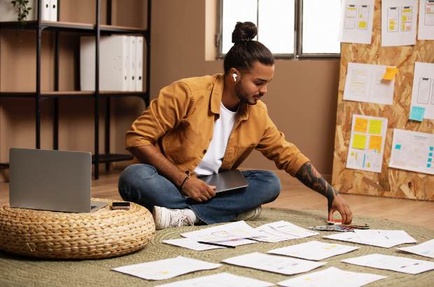 Homem jovem trabalhando em planejamento de novo projeto para sair de sua zona de conforto em seu escritório 