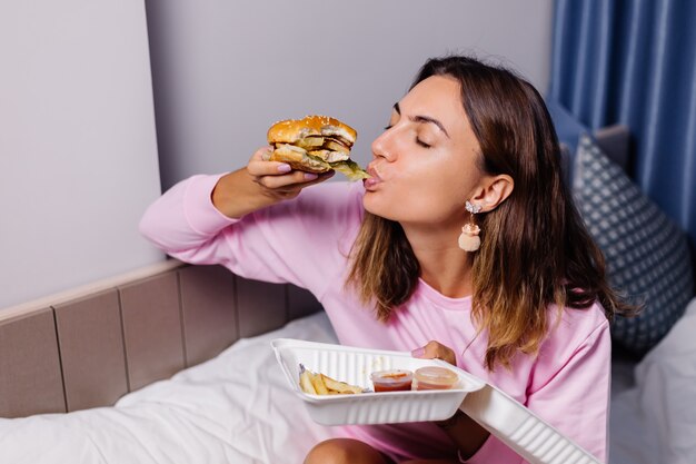 Mulher comendo hambúrguer