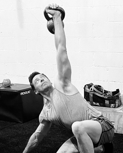 Hugh Jackman fazendo exercício de kettlebell com um braço