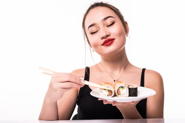 Mulher comendo comida japonesa