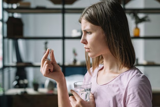 Mulher preocupada tomando suplemento vitamínico